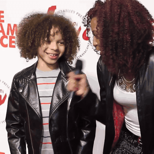 Looping clip: Chelsea and a young dancer trading moves on the Phazes of Love red carpet